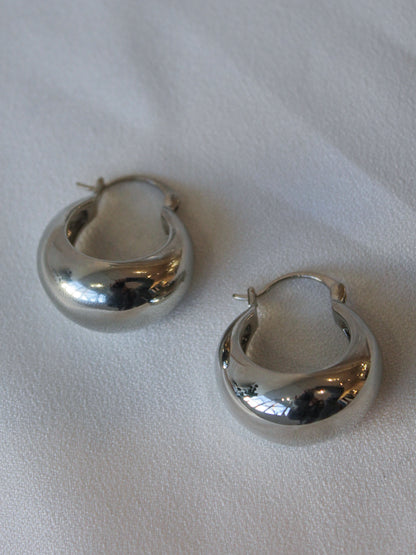 A pair of bold, silver hoop earrings