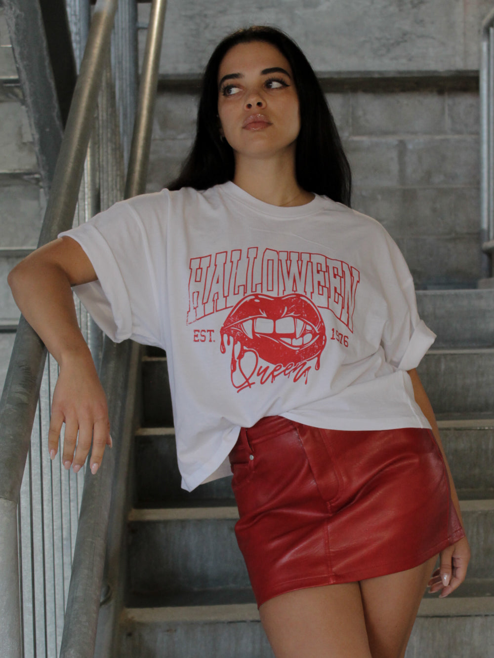 GIRL WEARING A HALLOWEEN QUEEN CROPPED TEE AND RED LEATHER SKIRT
