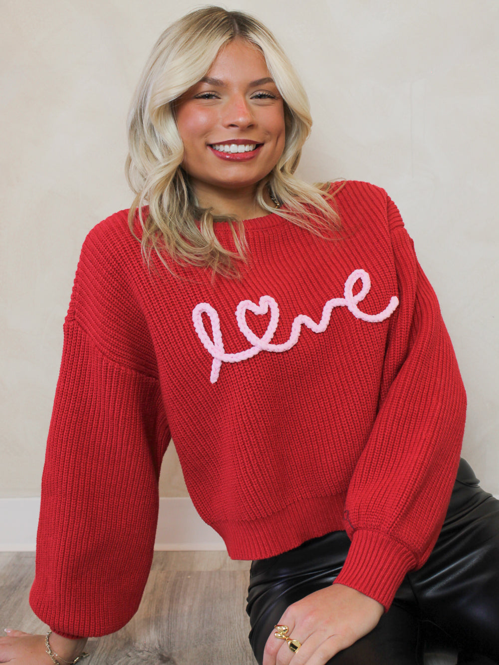 Red knit sweater with love script across chest