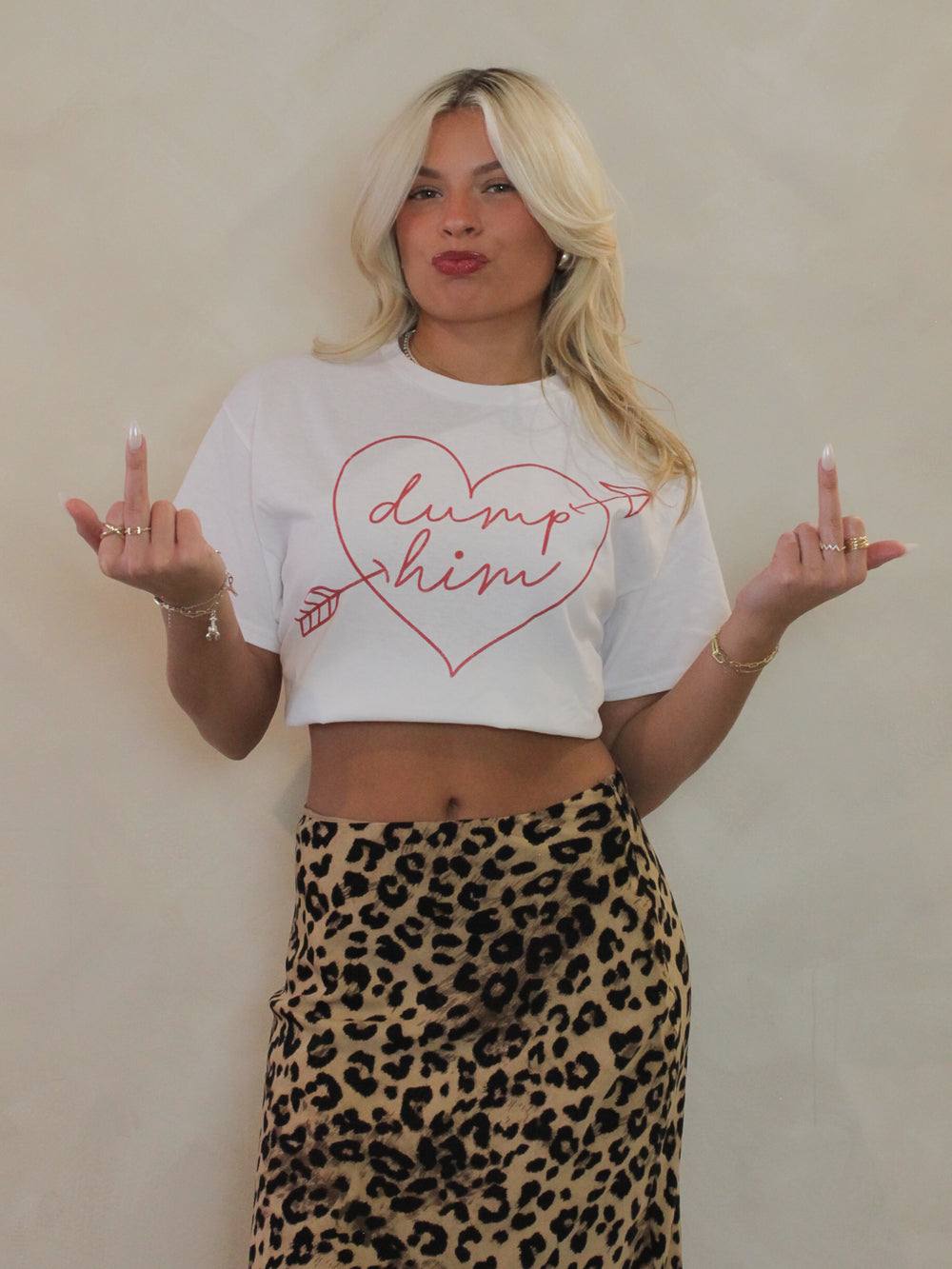 White tee with a heart graphic that says dump him paired with a leopard skirt 